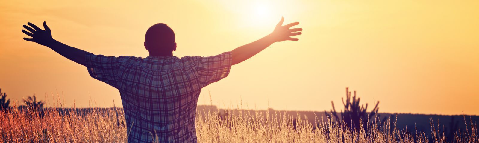 Man in field happy about addiction recovery