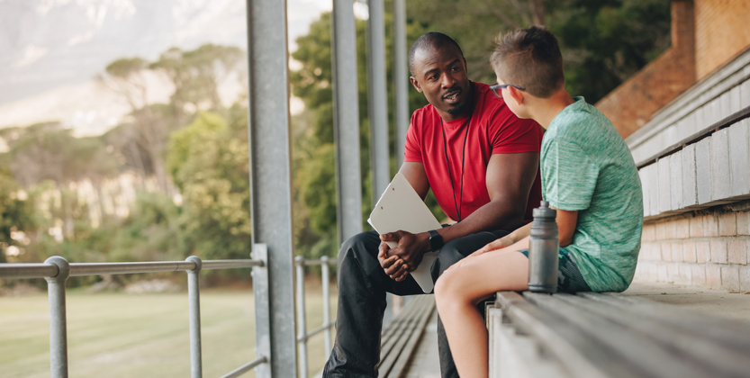 Man talking to child on bench